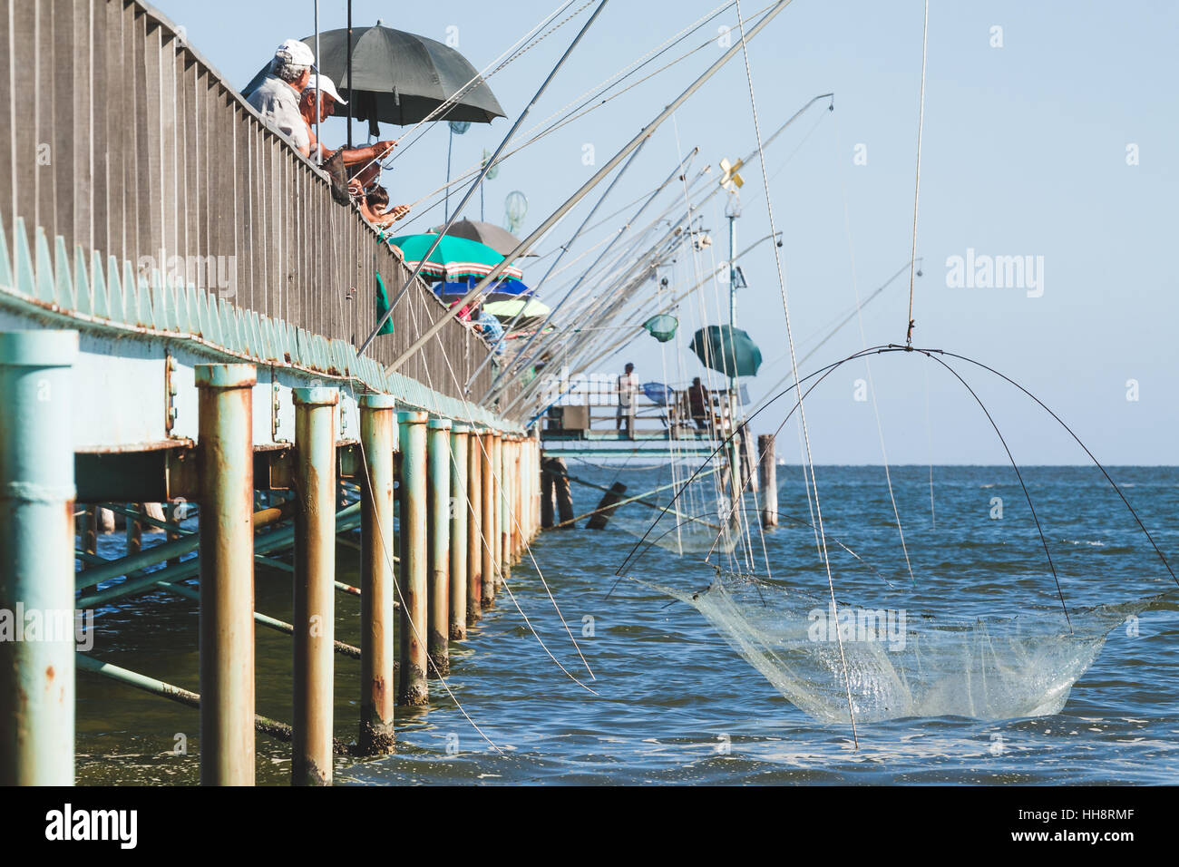 Fishing from the pier or fishing wharf with fishing net and rod at