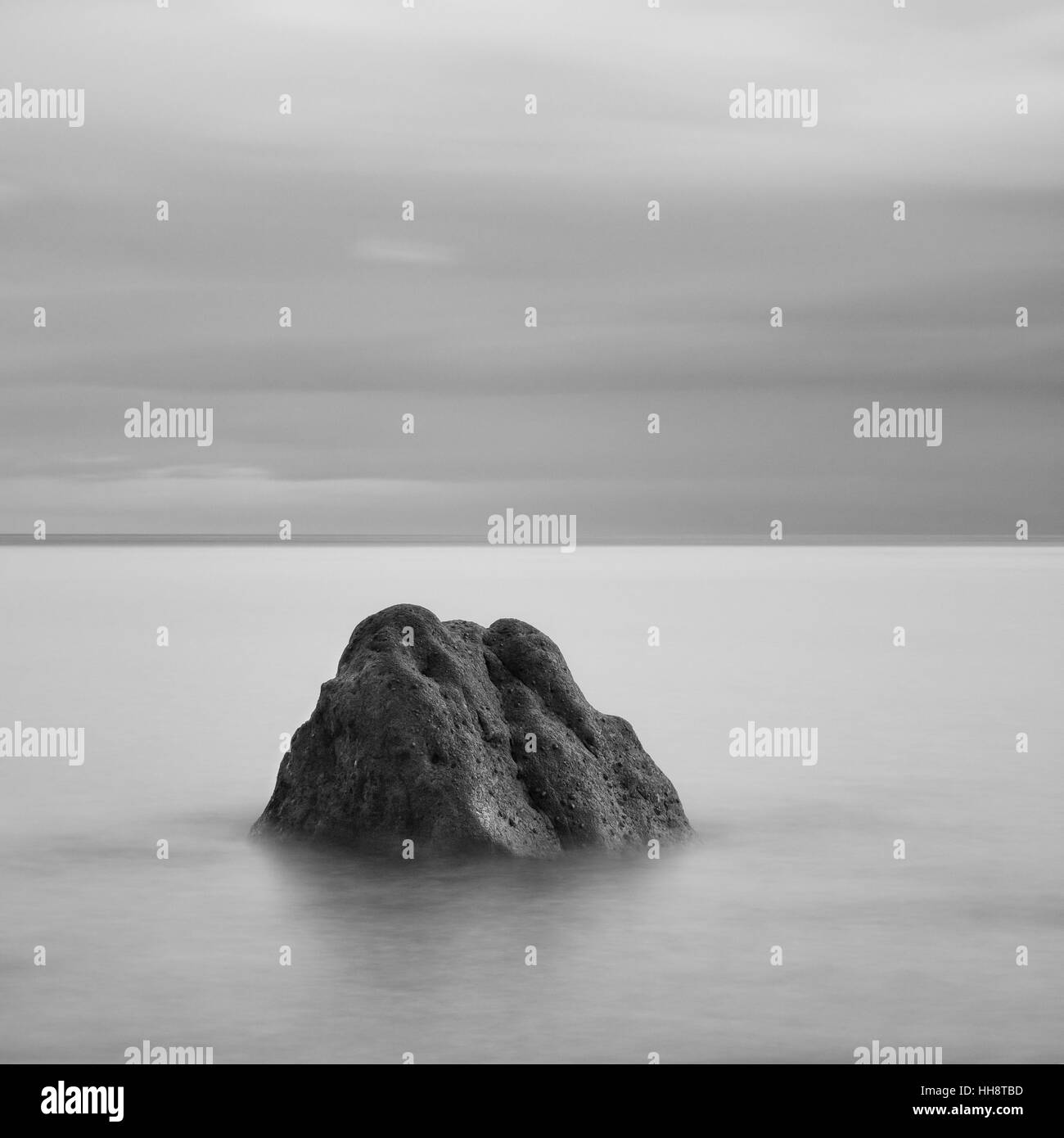 Single rock on the shoreline Stock Photo