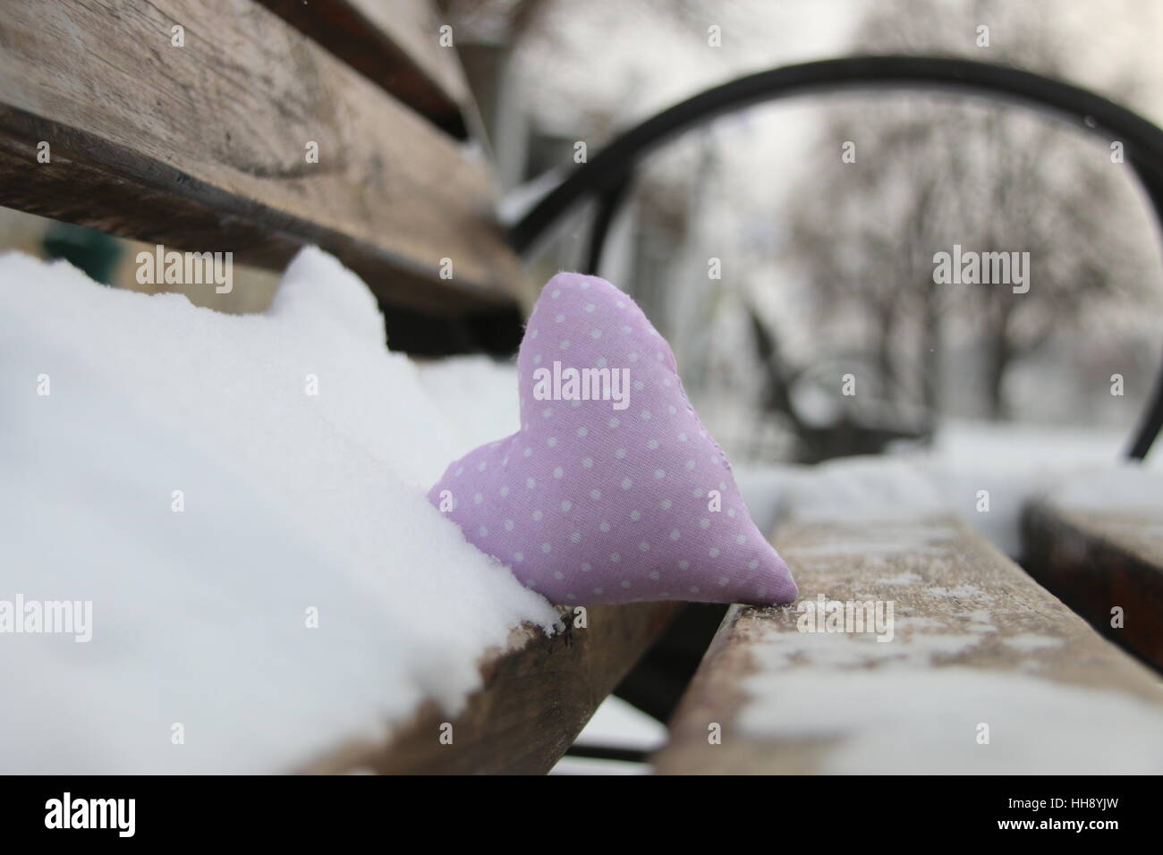 Bench with heart in winter park. Valentines day card or Love idea. Stock Photo