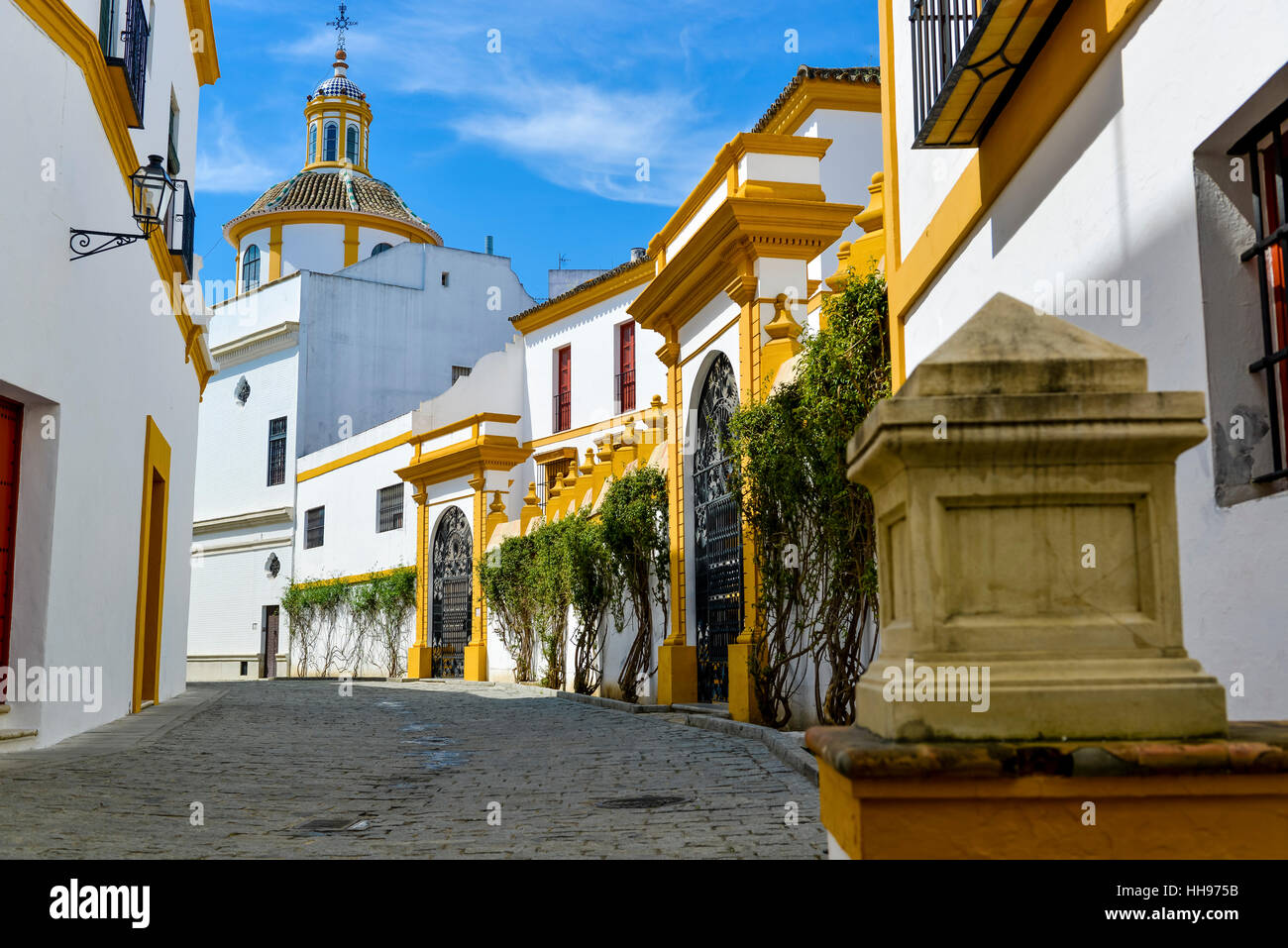 white with yellow decorated houses in the old streets of Seville, Spain
