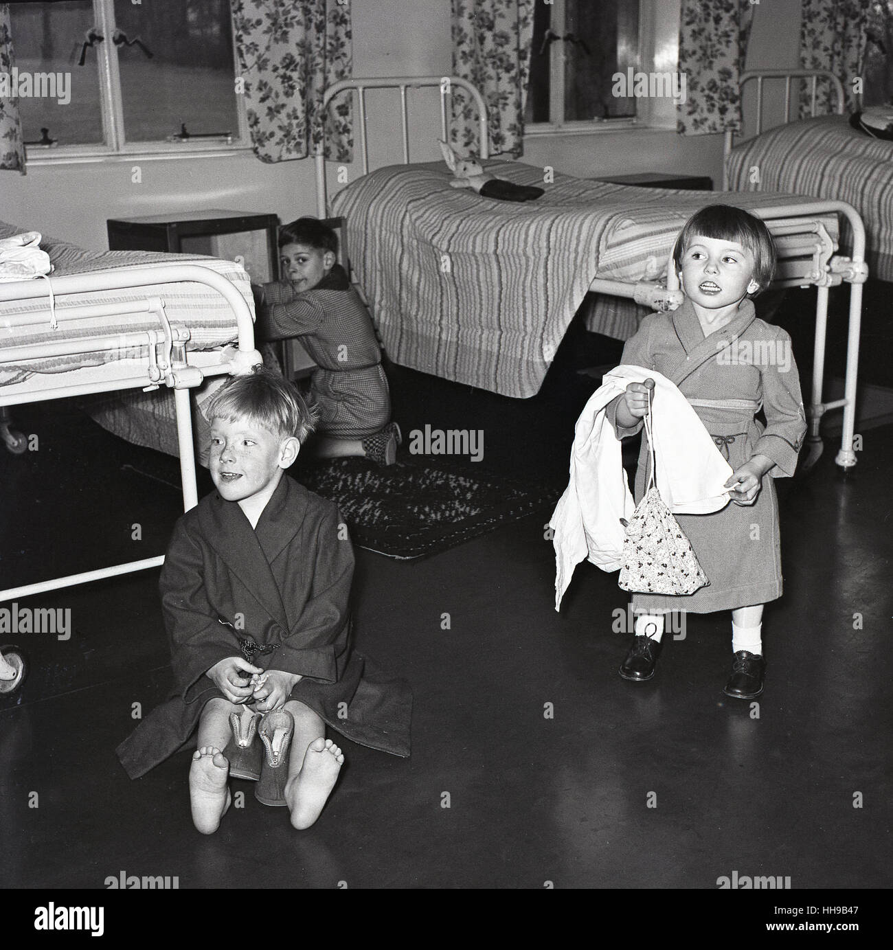 1950s, historical, children's hospital, small children in dressing gowns on ward by beds Stock