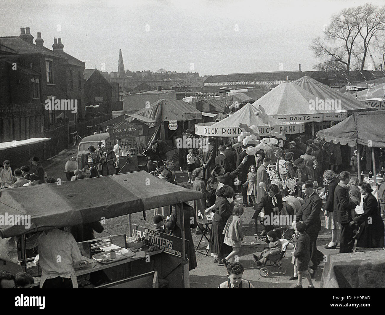 1950s, people attending a local outdoor fair with candy floss, sugared apple fritters, a duck