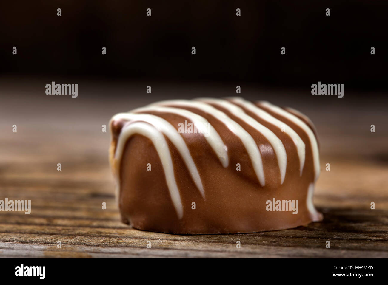 Close up of one chocolate candy over wooden background Stock Photo