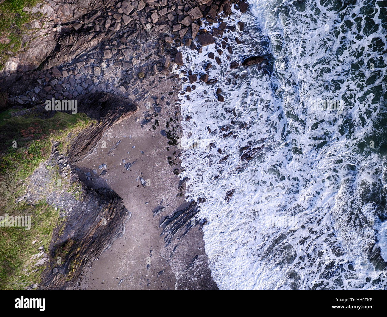 Cornwall beach with foaming waves crashing on rocks. Aerial photo Stock Photo