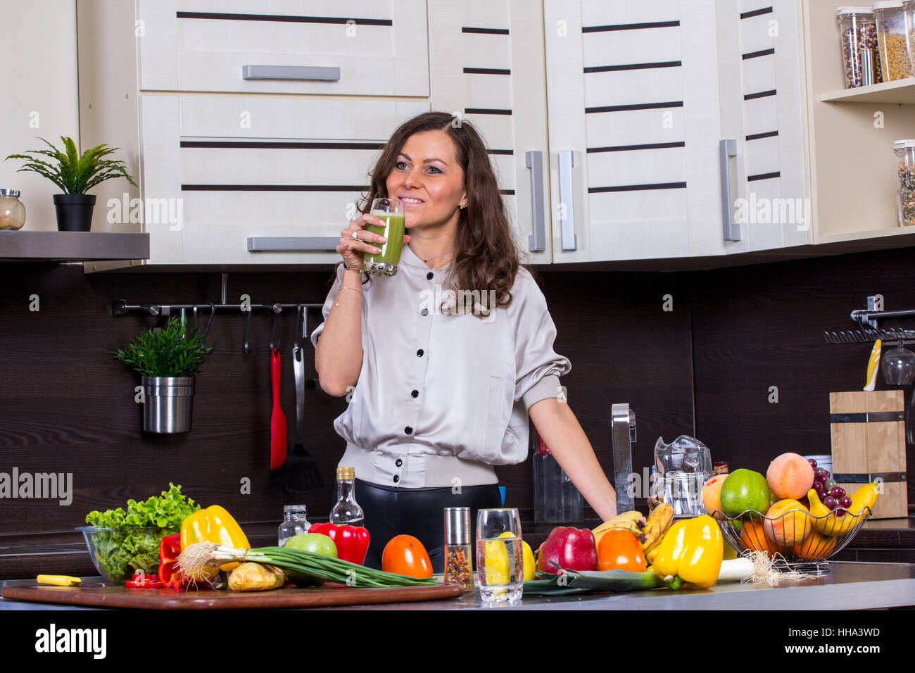 Young woman with drinking vegetable juice in kitchen Stock Photo Alamy