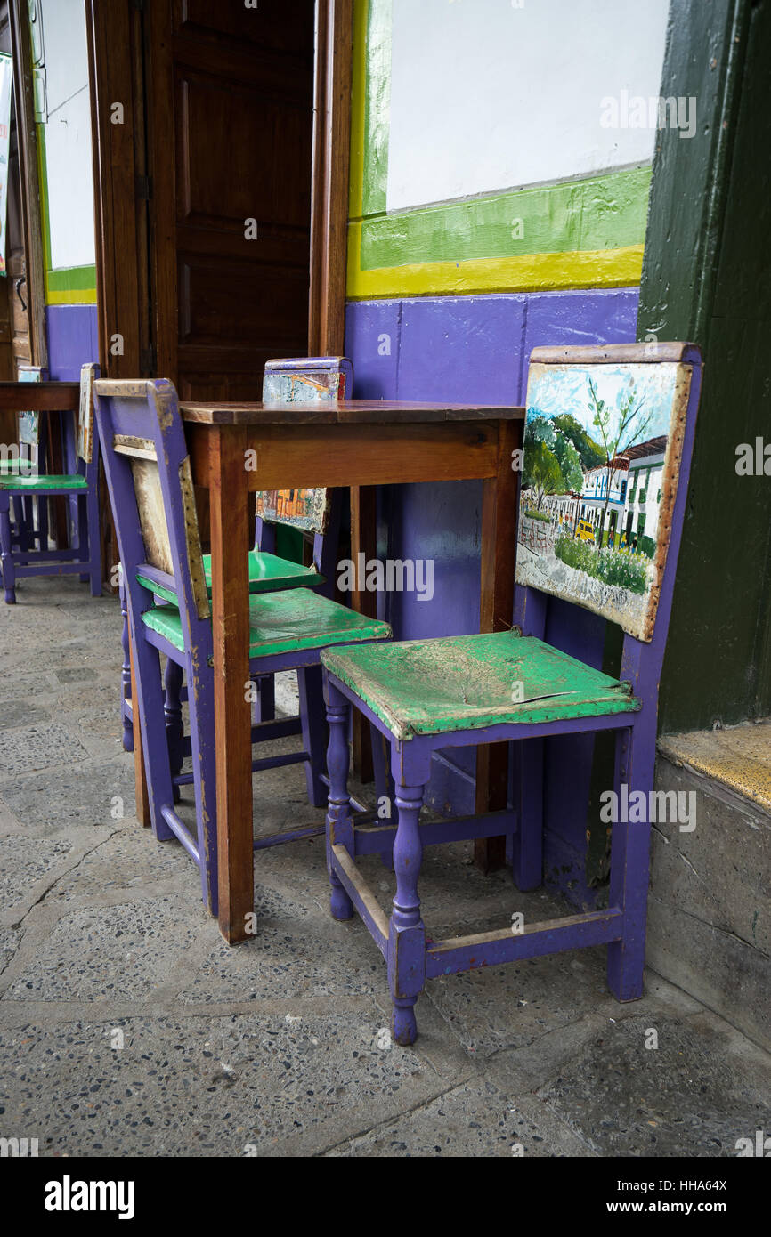 Small café with sidewalk patio chairs made of wood and cowhide painted colorfully Stock Photo