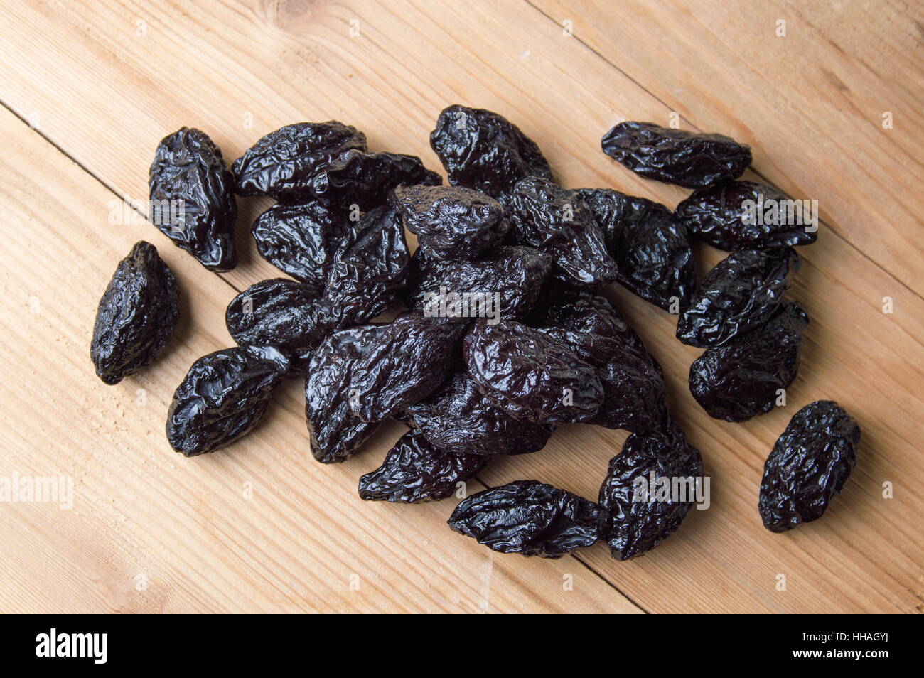 Bunch of dried plums on wooden table Stock Photo