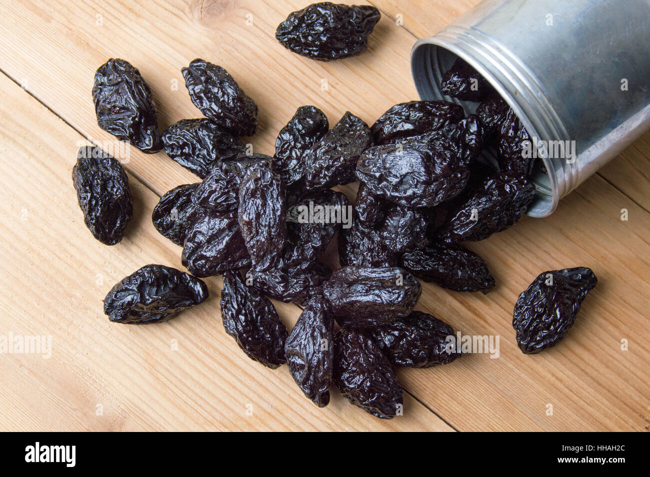 Dried plums in a metal can on the table Stock Photo