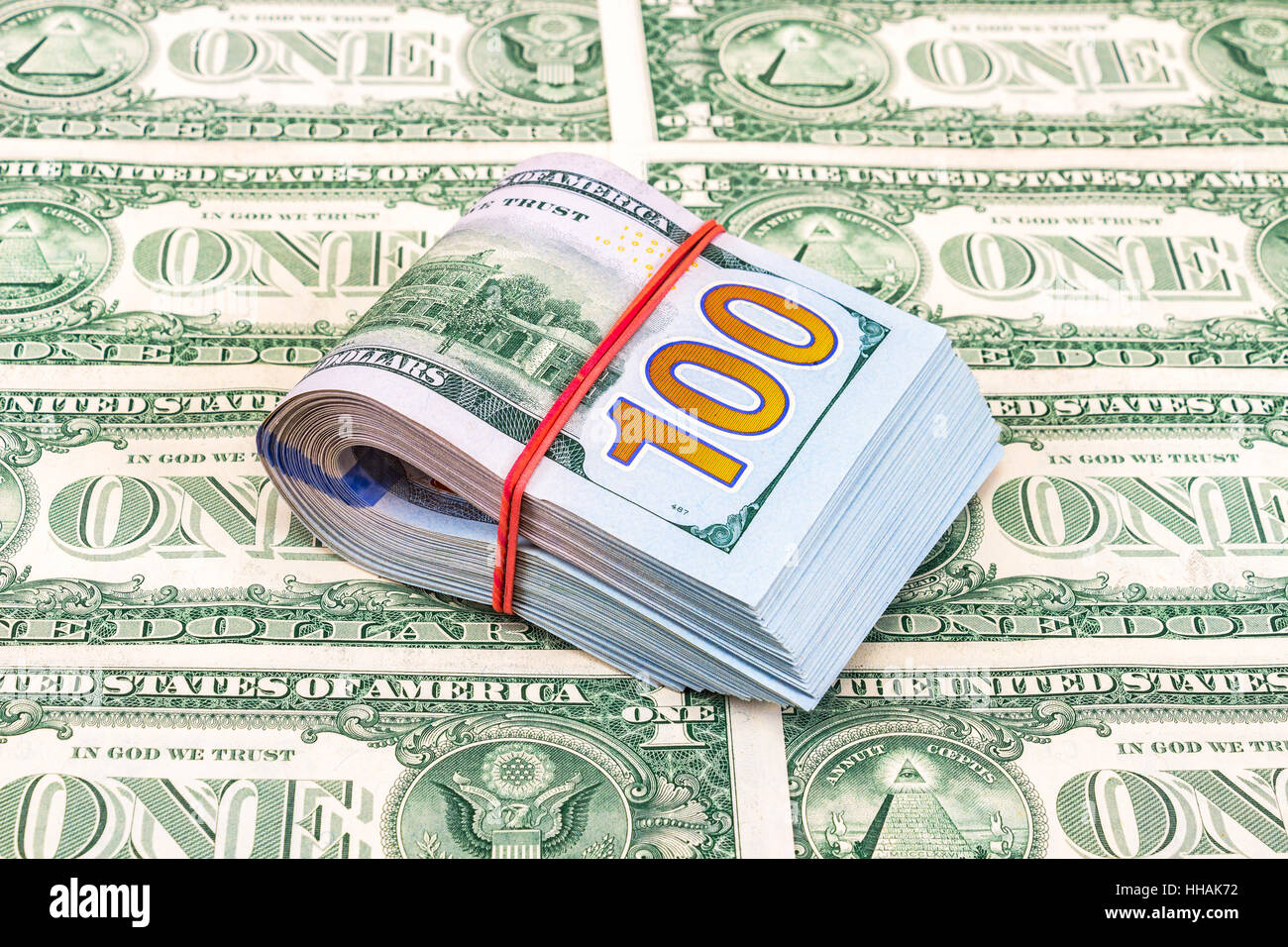 Folded dollar bills wrapped by rubber band over dollars banknotes Stock