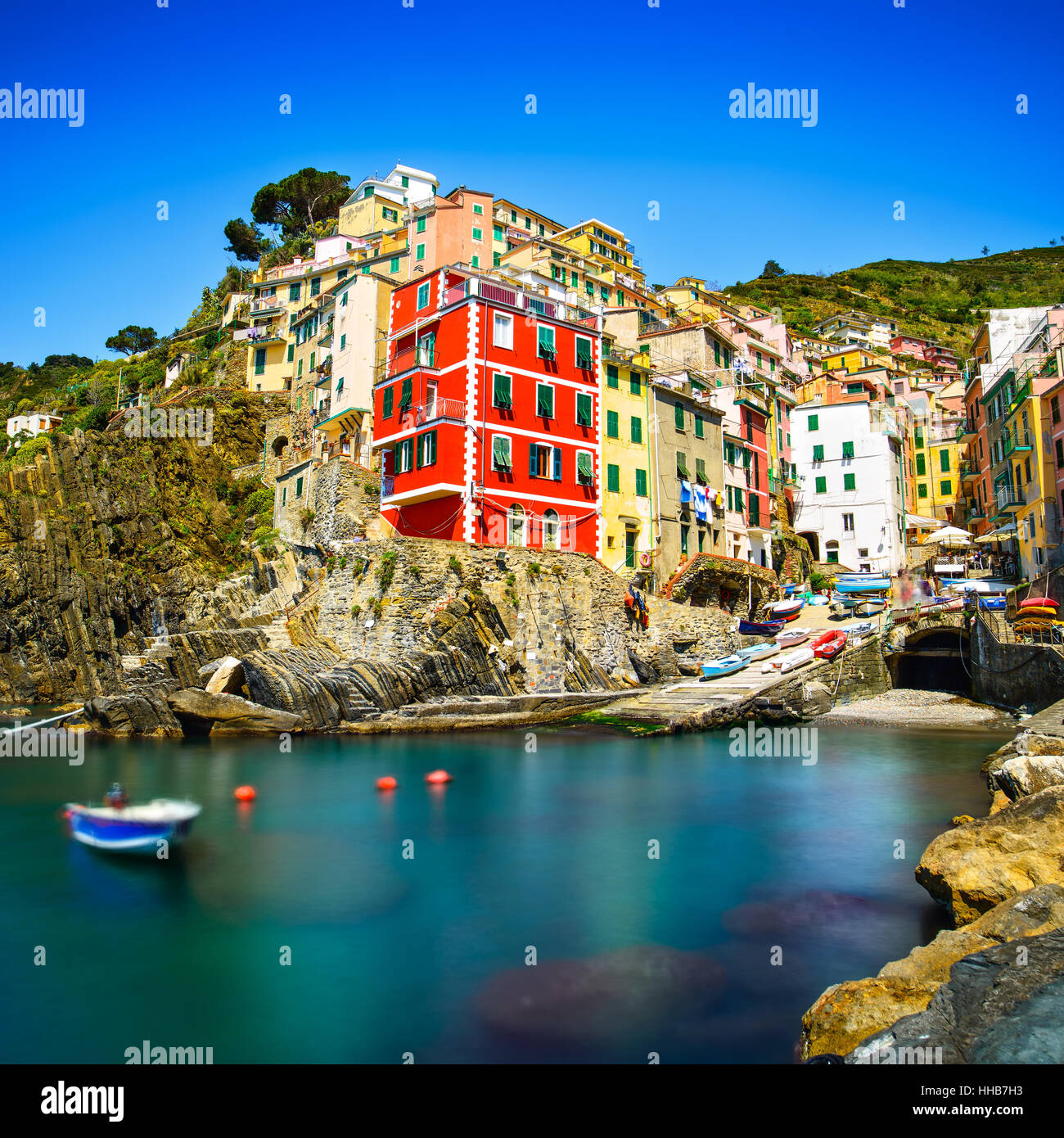 Riomaggiore village on cliff rocks and sea at sunset., Seascape in Five lands, Cinque Terre National Park, Liguria Italy Europe. Long Exposure Stock Photo