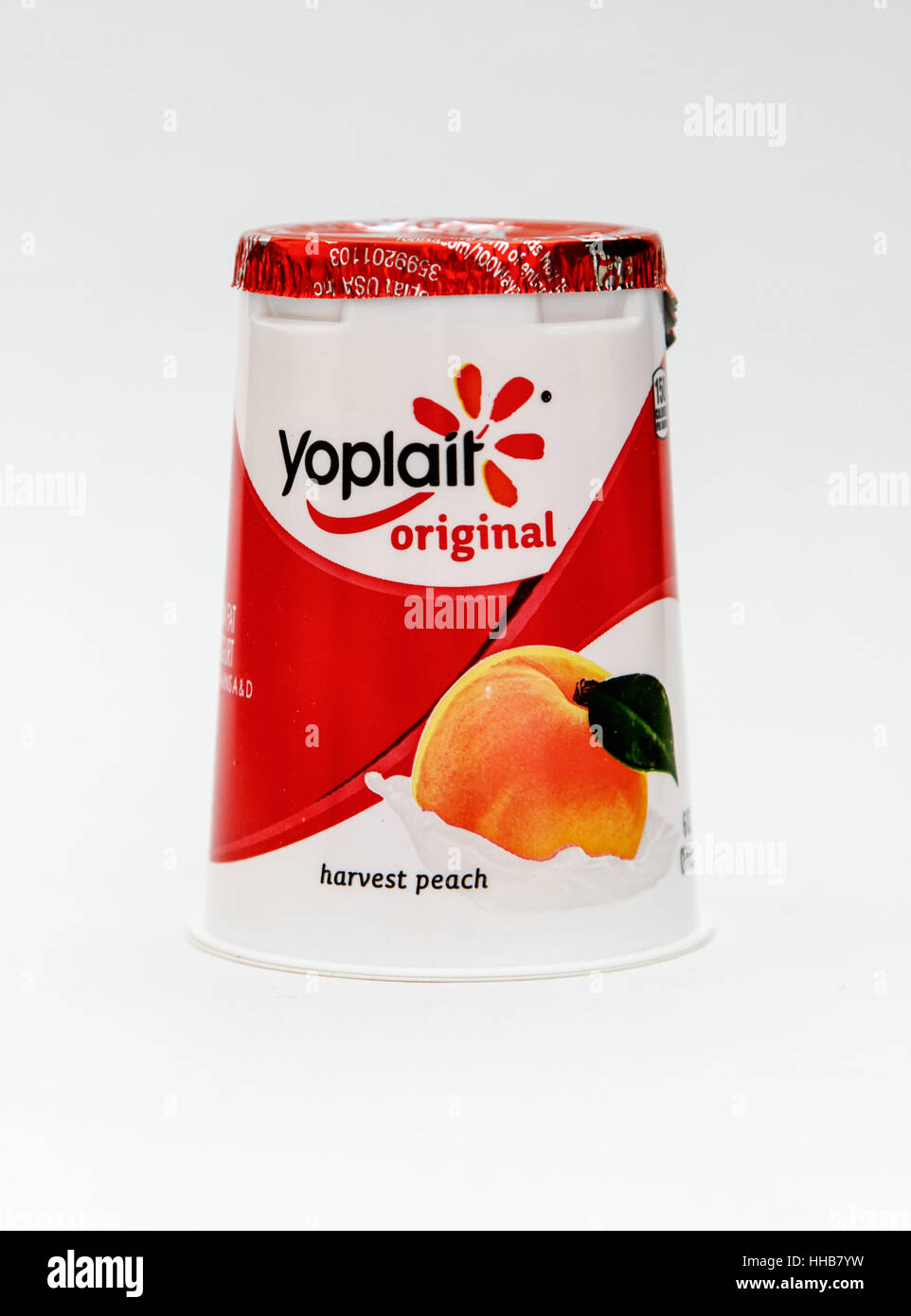 A peach flavored Yoplait yogurt is seen against white background. Stock Photo