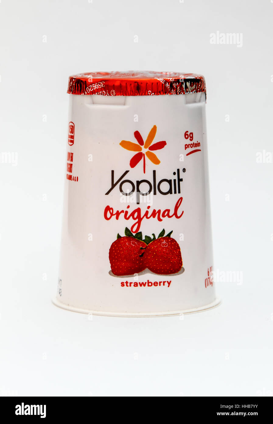 A strawberry flavored Yoplait yogurt is seen against white background. Stock Photo