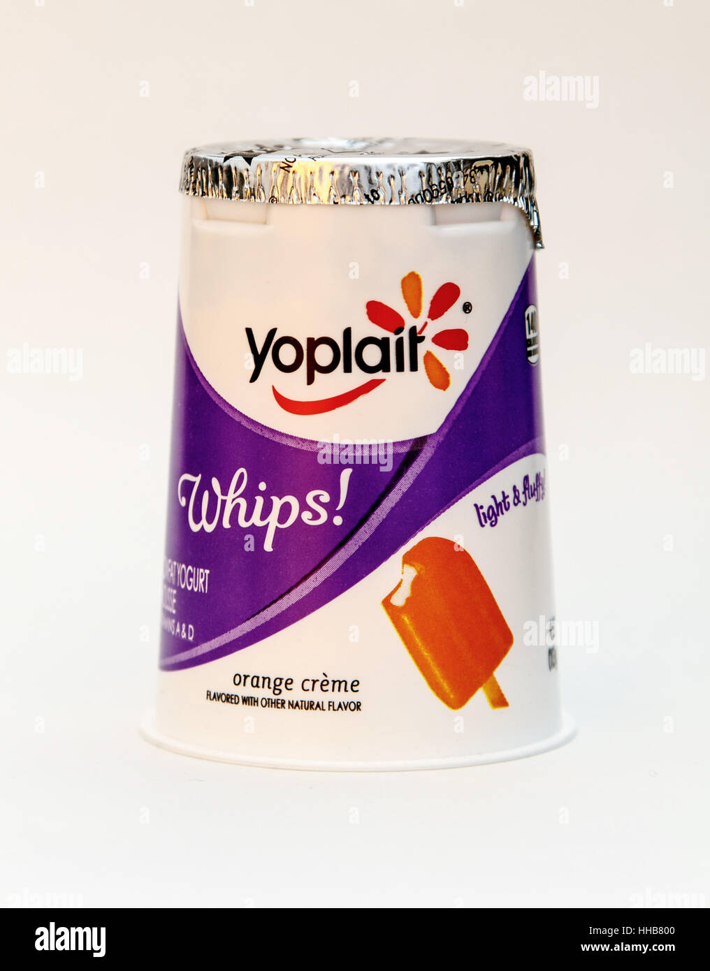 An orange creme flavored Yoplait whipped yogurt is seen against white background. Stock Photo