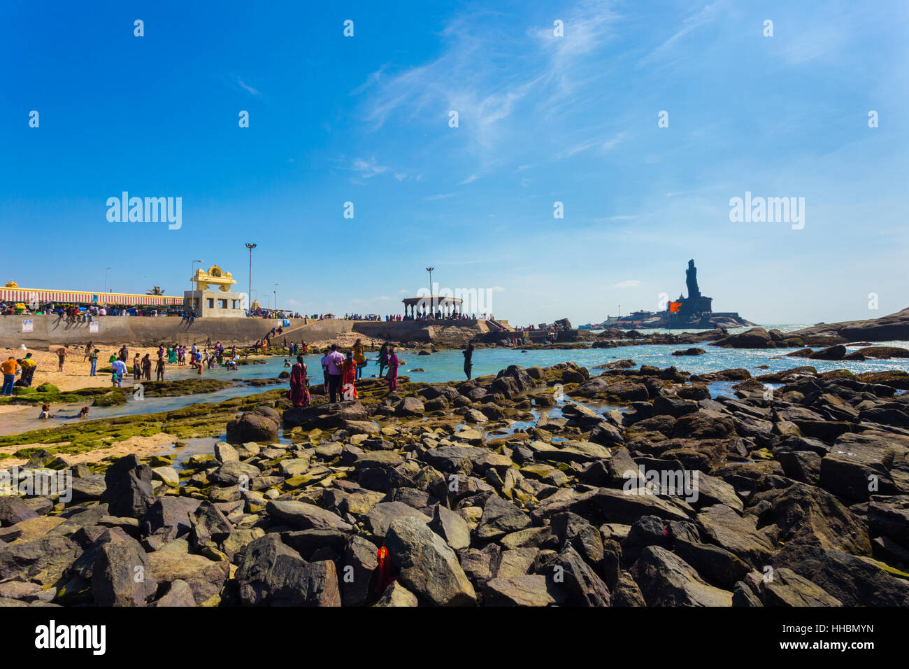 Indian tourists swimming in shallow ocean water near Thiruvalluvar statue and 16 legged mandap pavilion in southernmost tip city Stock Photo