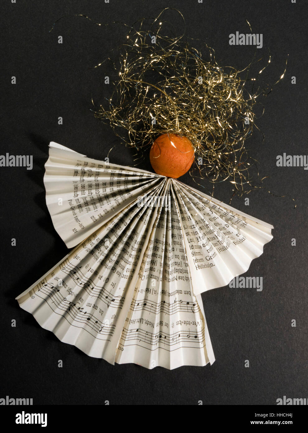 studio photography of a hand made paper angel in dark back Stock Photo
