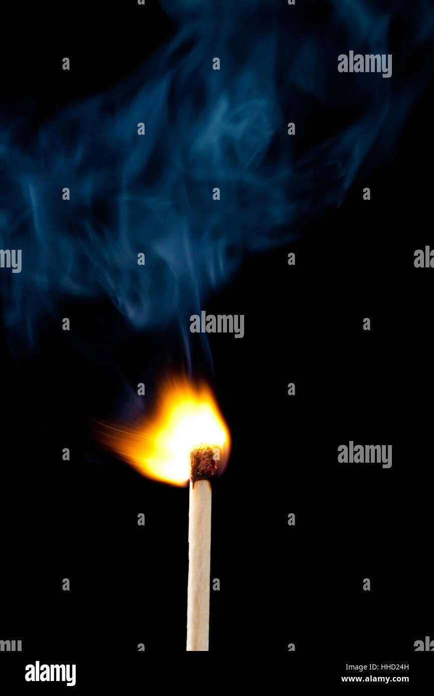 Setting fire to a match against a black background Stock Photo - Alamy