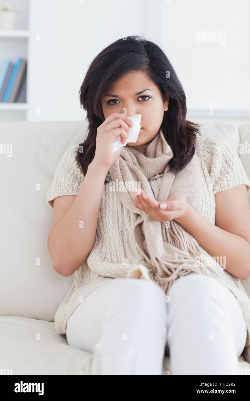 Woman blowing her nose in a living room Stock Photo Alamy