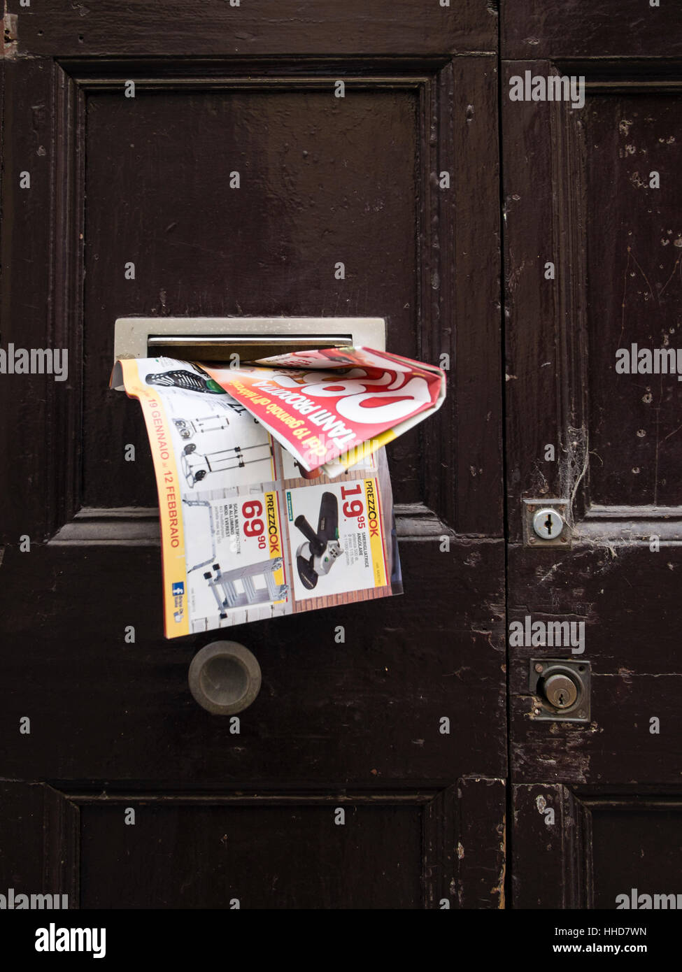 Junk mail in door handle or posto boxes in Italy. Stock Photo