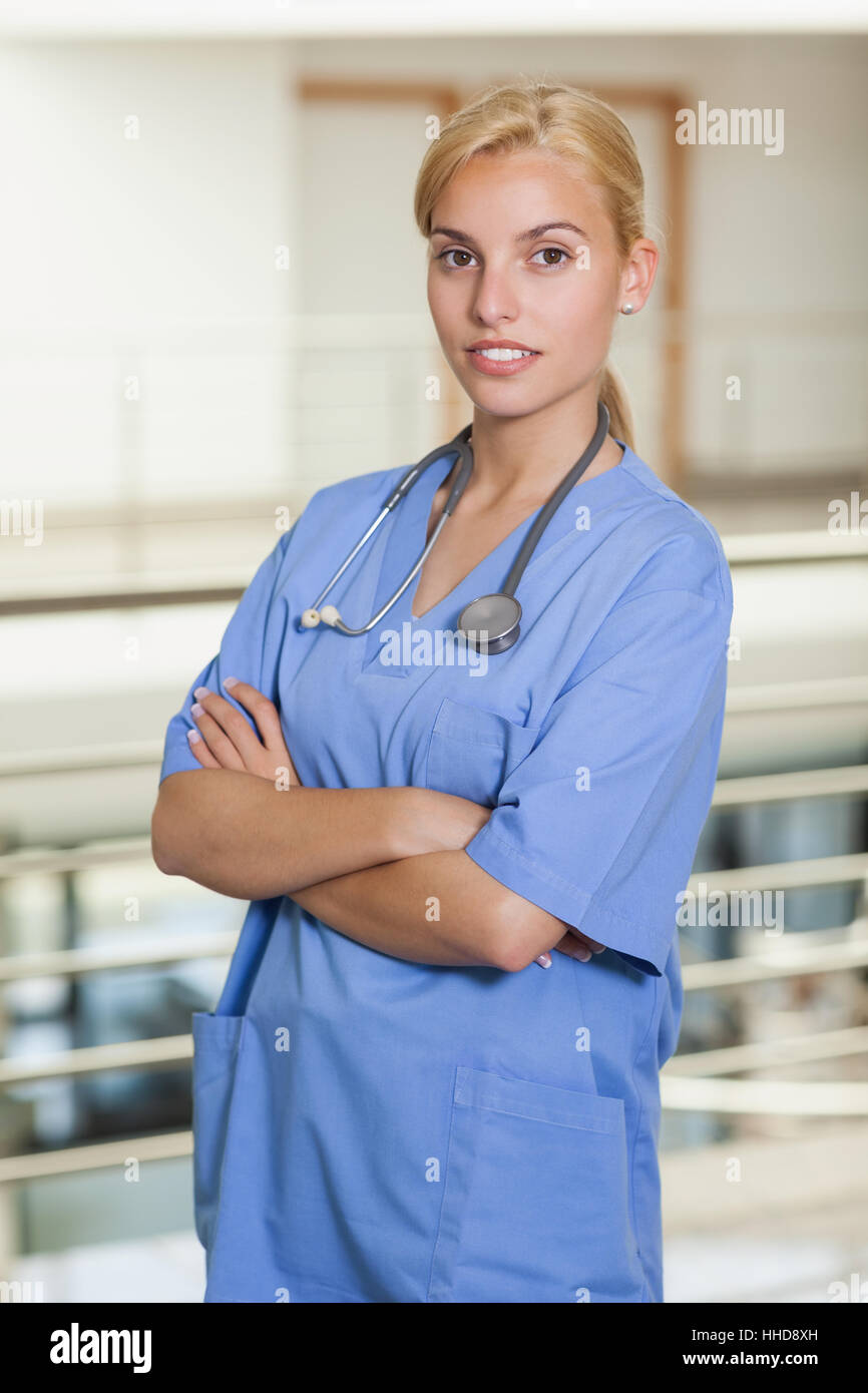 Blonde nurse with arms crossed in hospital corridor Stock Photo - Alamy