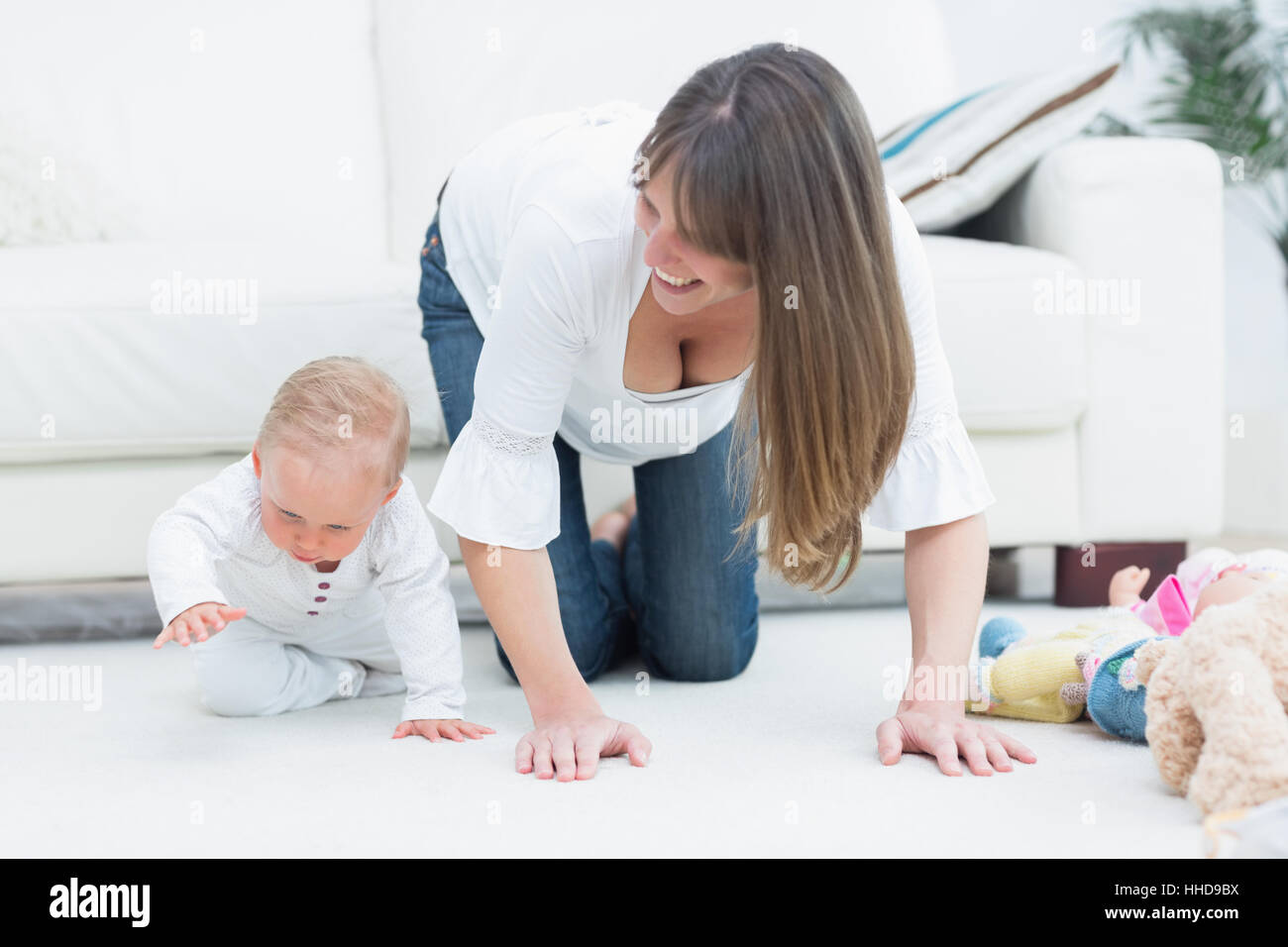 Mother on all fours next to a baby in living room Stock Photo Alamy
