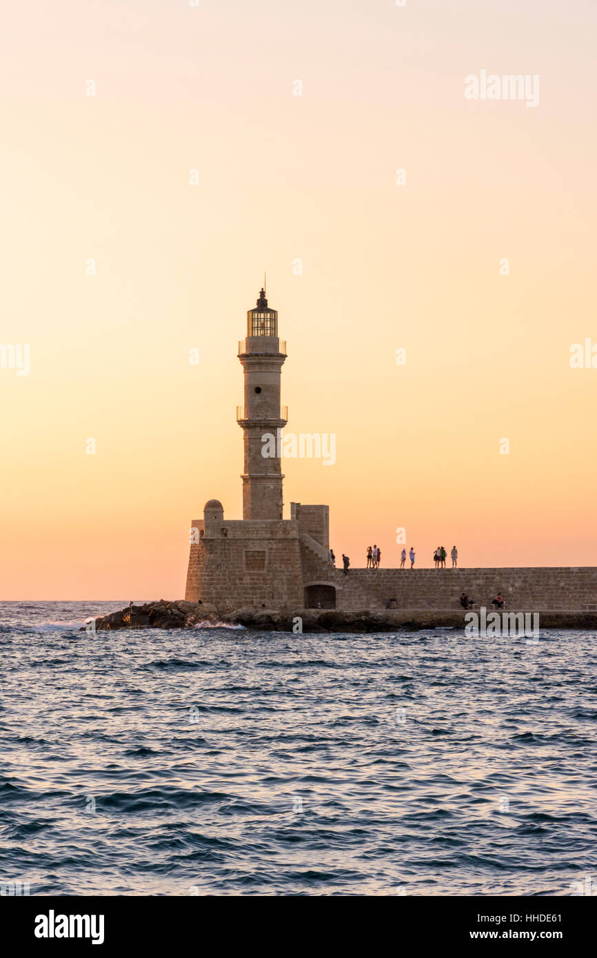 Sunset over the Chania lighthouse at the entrance to the Venetian harbour of Chania, Crete, Greece Stock Photo