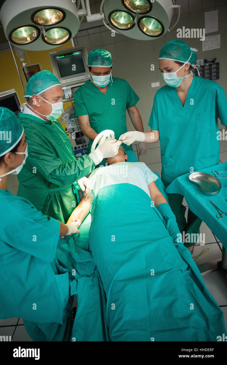 Surgeon working on the arm of a patient with a team of surgeons in a