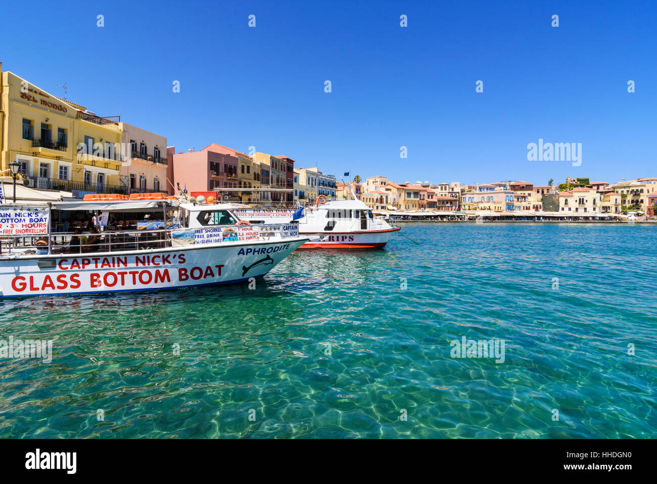 Tourist boats along the waterfront promenade around the old outer Venetian harbour of Chania, Crete, Greece Stock Photo