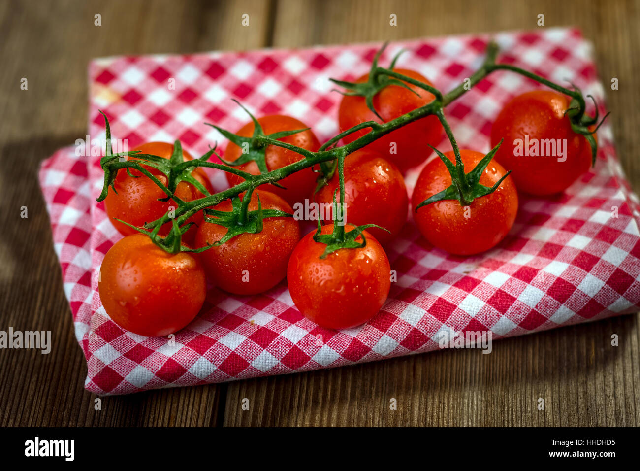 Red cherry tomatoes on an old wooden table in rustic style Stock Photo ...