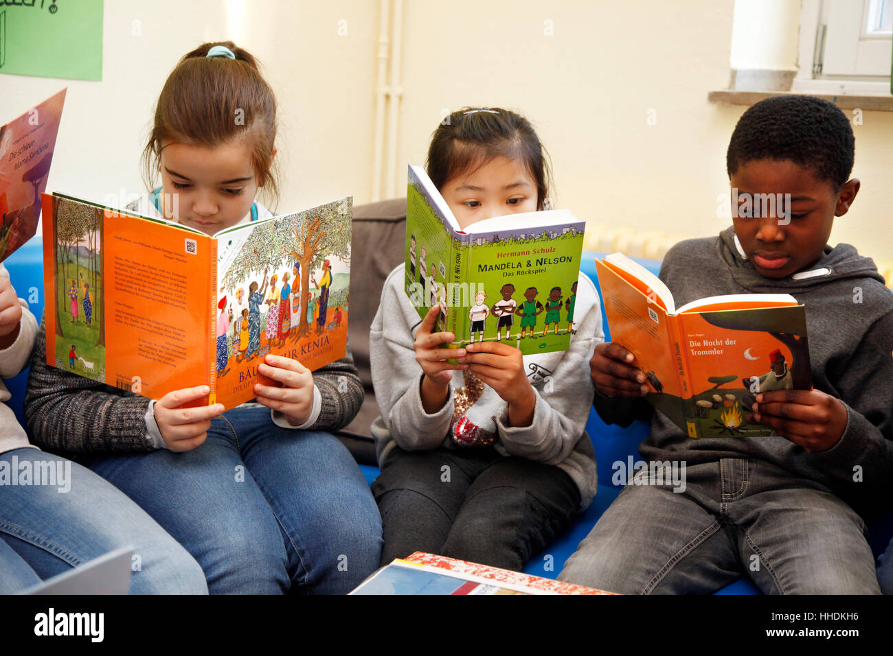 Pupils at a primary school read books about the live in Africa. Stock Photo