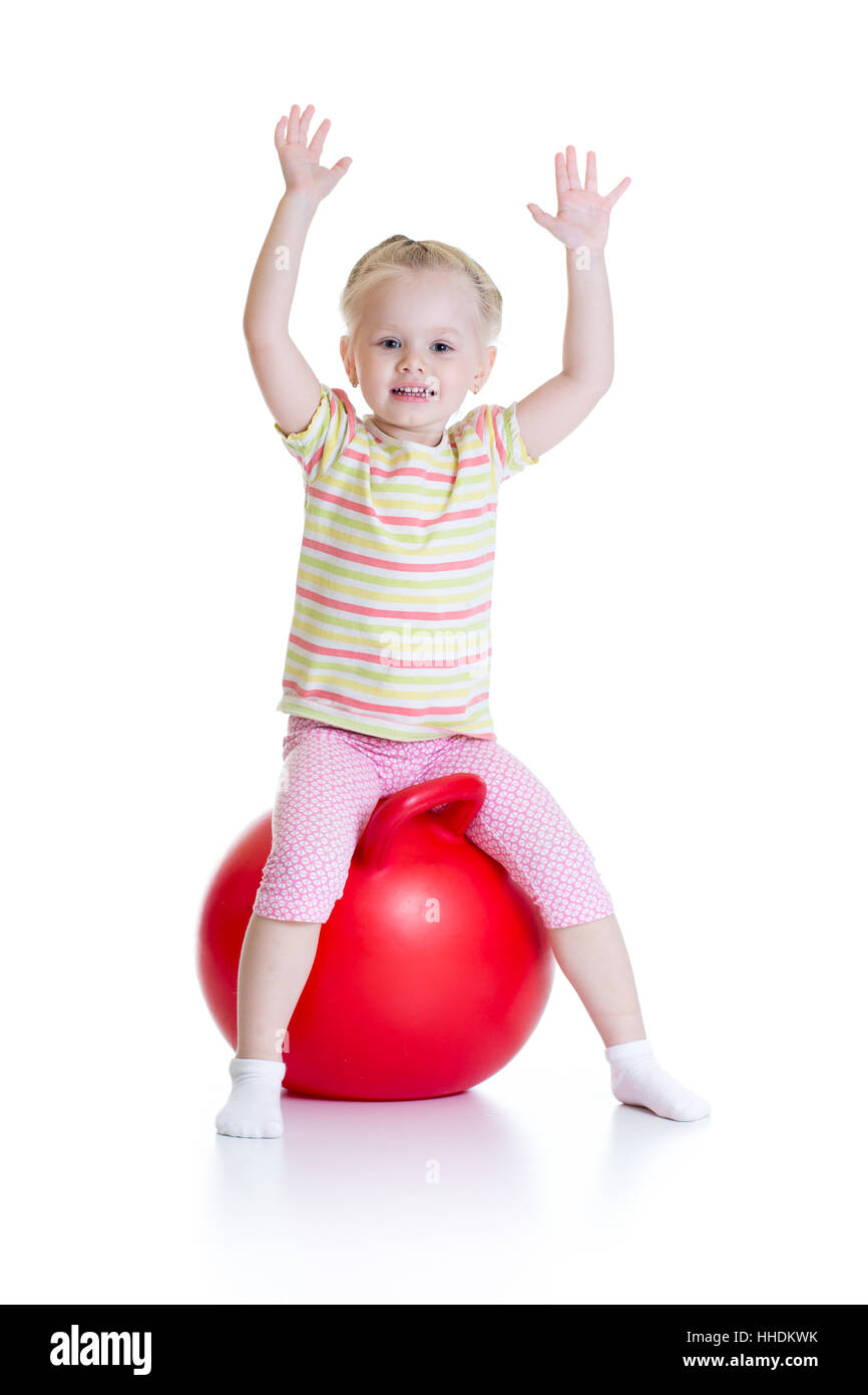 Smiling little girl jumping on a big ball isolated white background Stock Photo