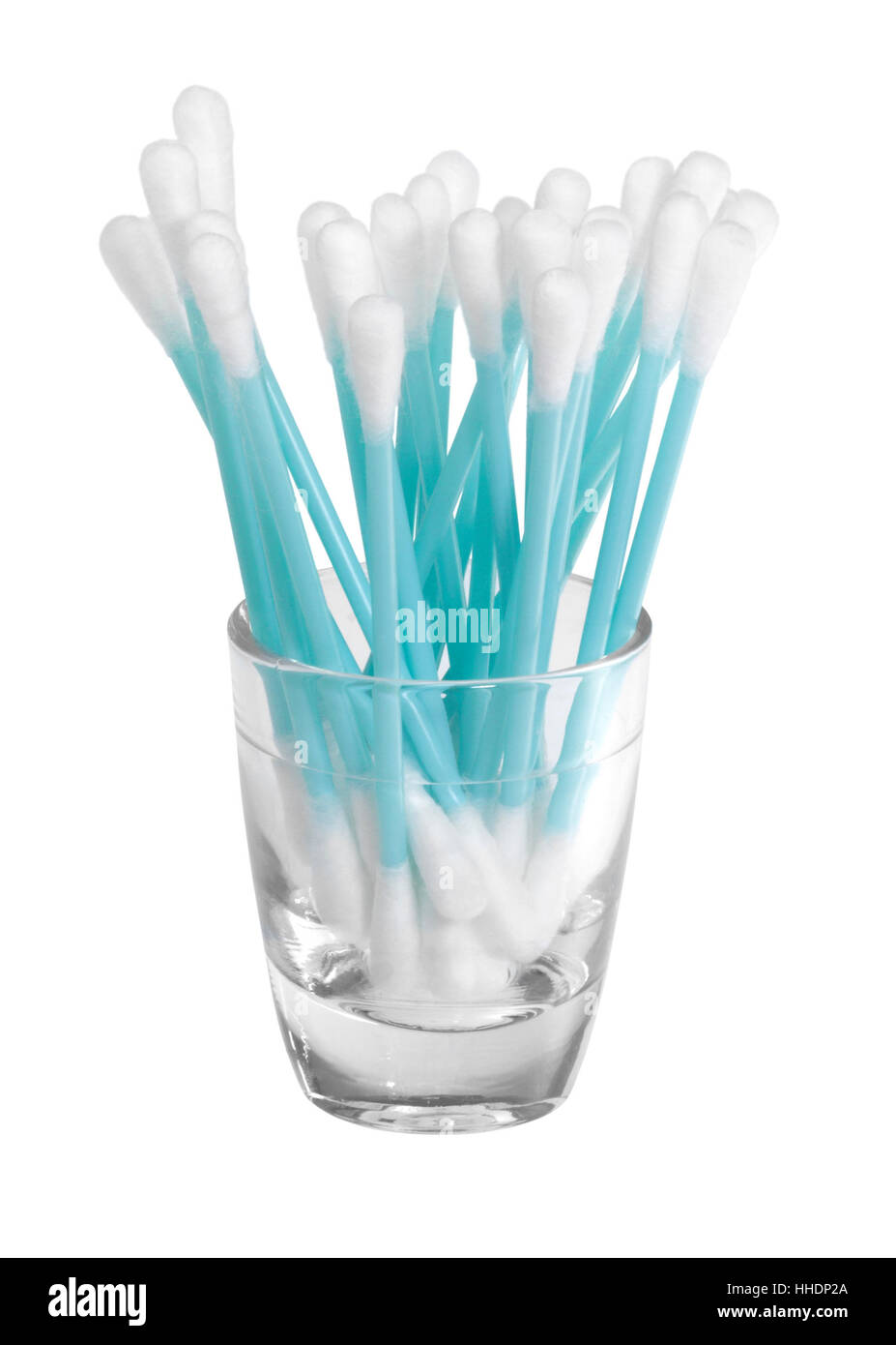 some cotton swabs standing in a liquid-filled small glass in front of white back Stock Photo