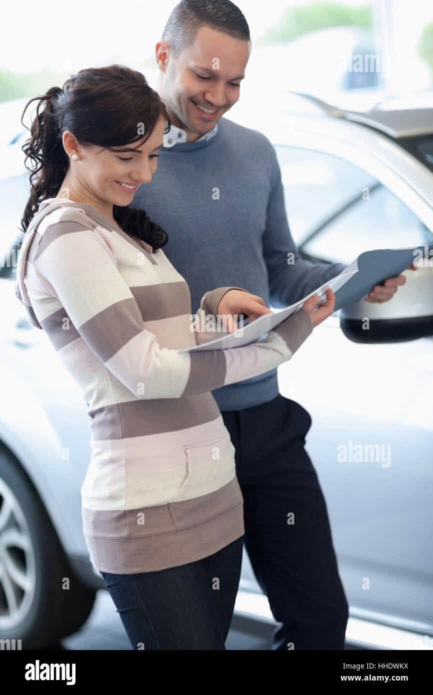 Couple holding documents in a carshop Stock Photo