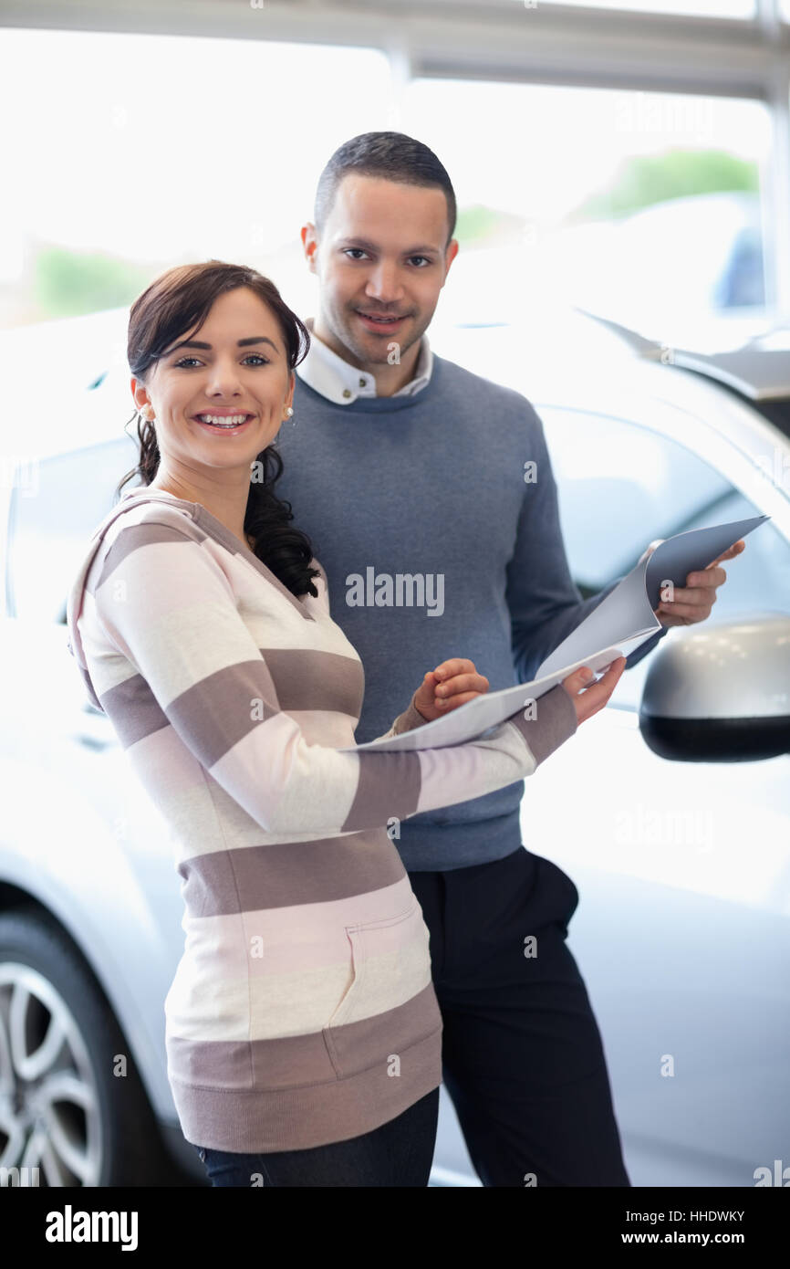 Smiling couple holding a document in a carshop Stock Photo