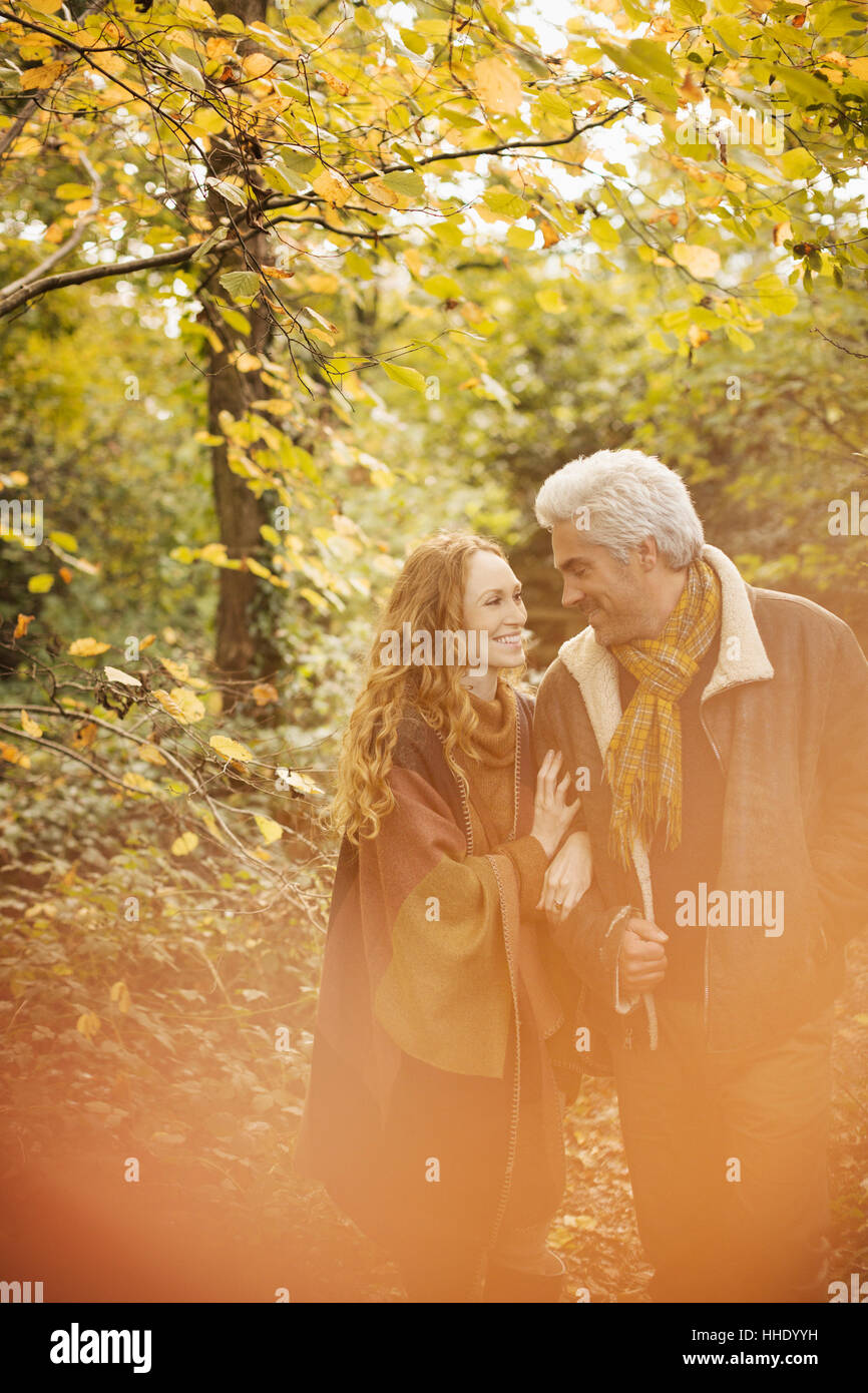 Affectionate couple walking arm in arm in autumn woods Stock Photo