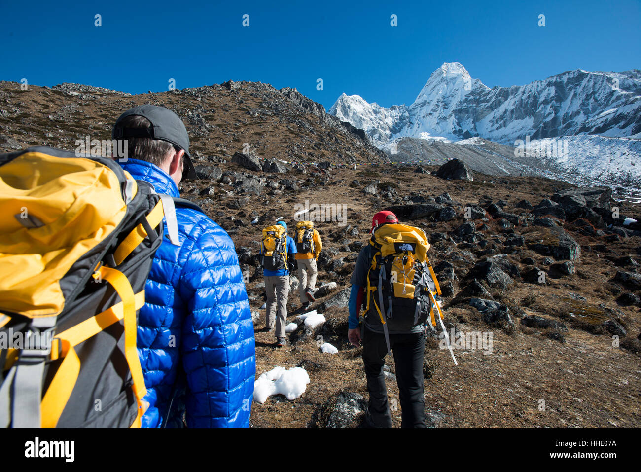 A team of four climbers make their way to Ama Dablam Base Camp, the 6856m peak seen in the distance, Khumbu Region, Nepal Stock Photo