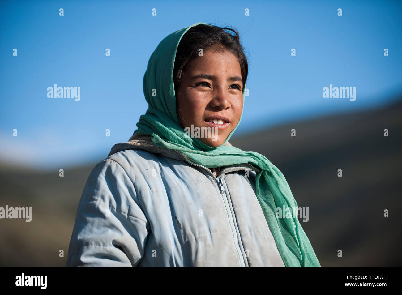 A nomad girl smiles as her father comes home from the hills, Ladakh, India Stock Photo