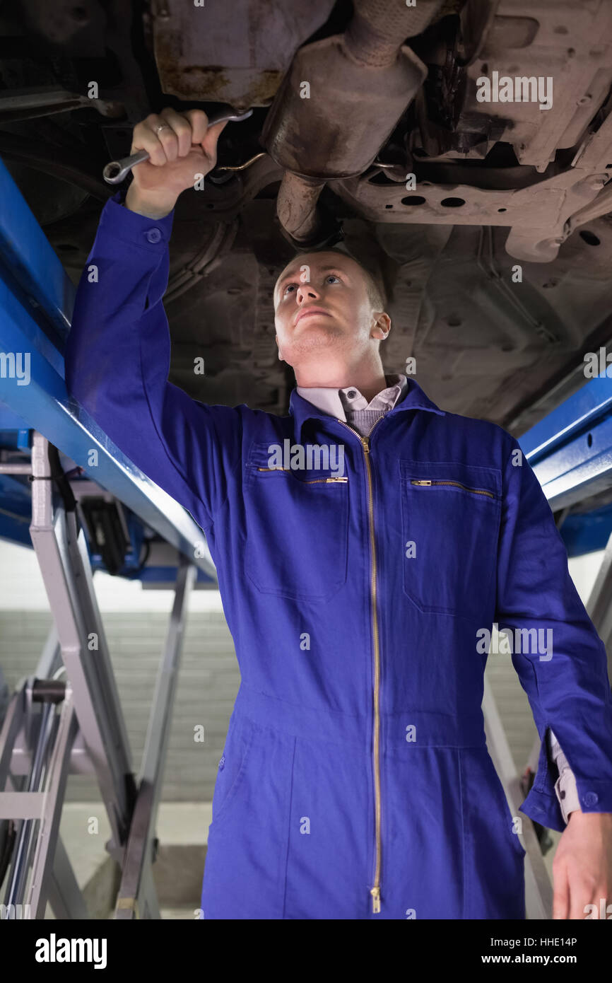 Concentrated mechanic repairing with a spanner in a garage Stock Photo