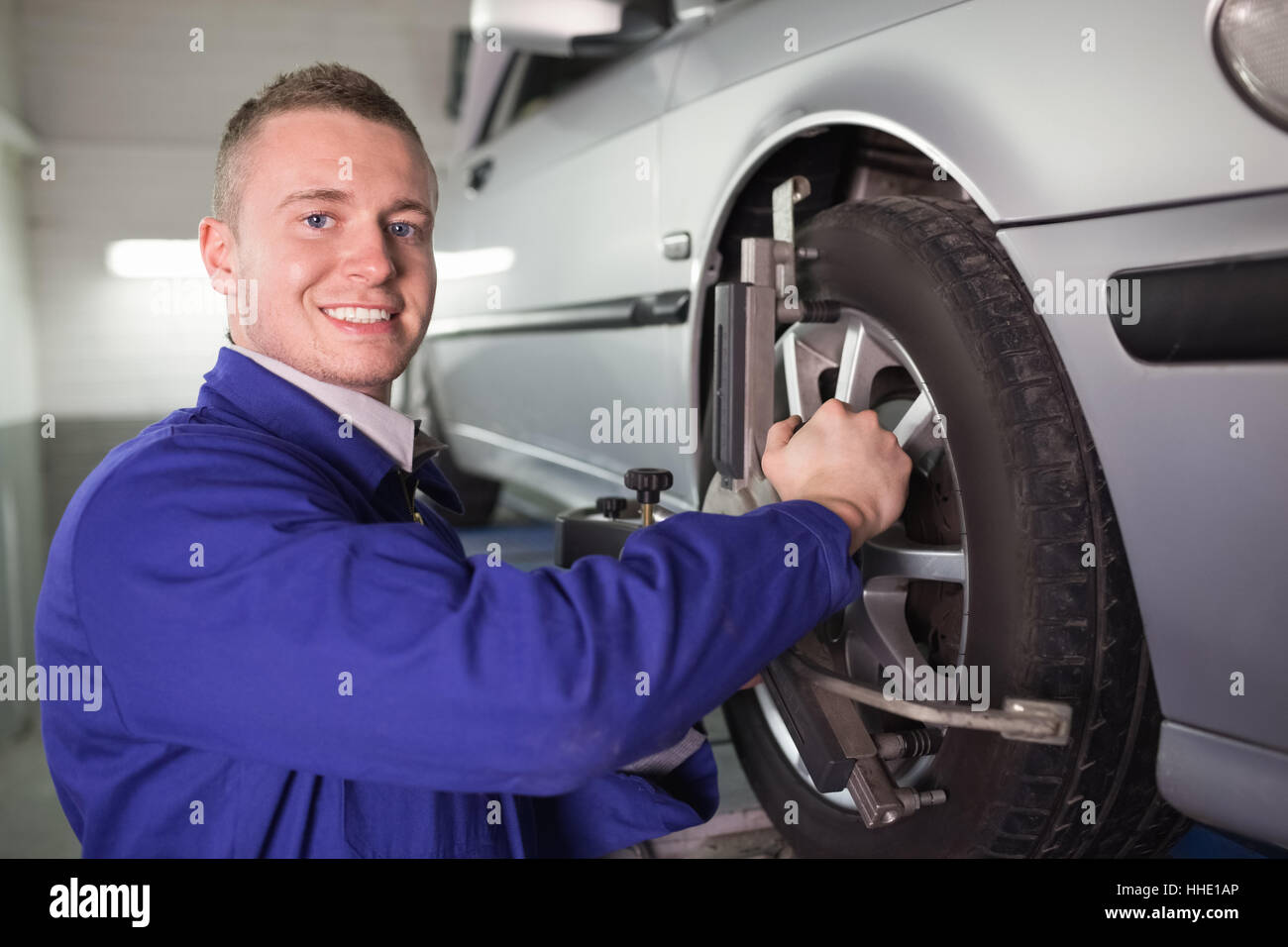 Mechanic repairing a car wheel in a garage Stock Photo - Alamy