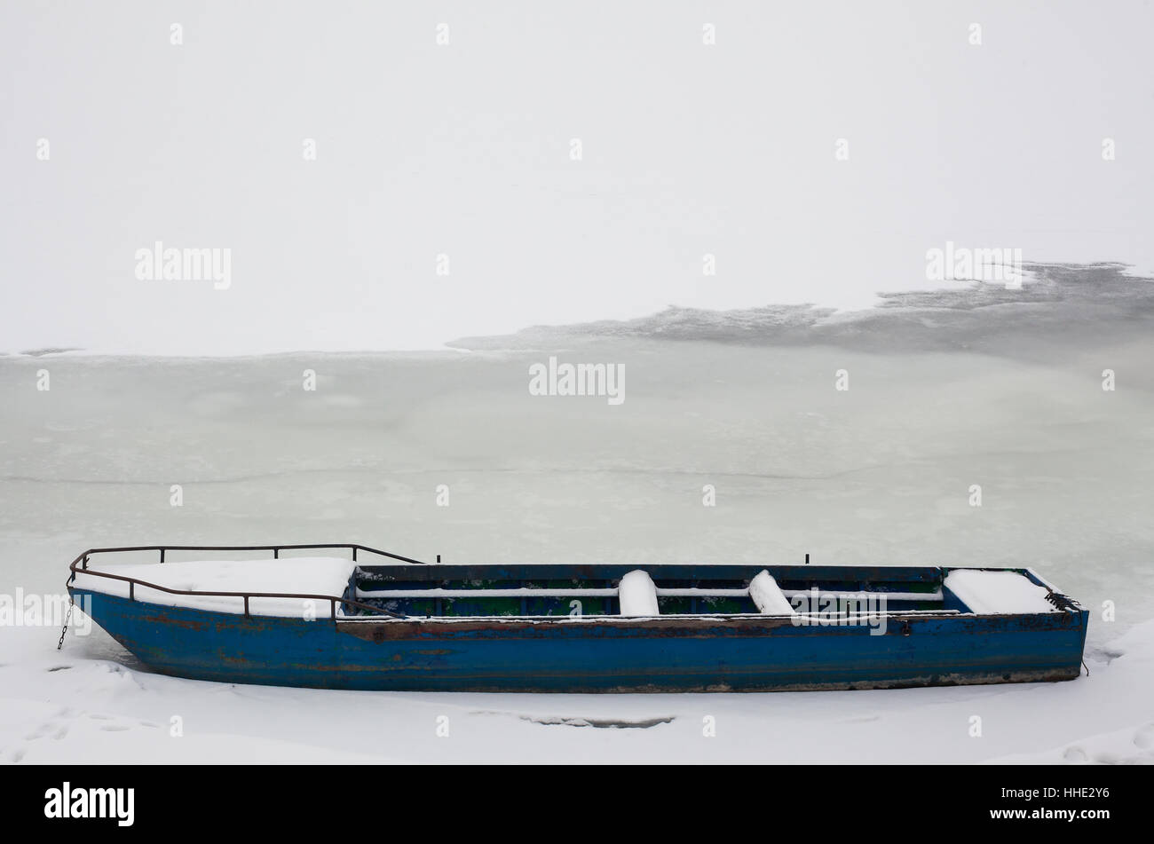 Abstract composition of an old wooden boat and frozen river. Stock Photo