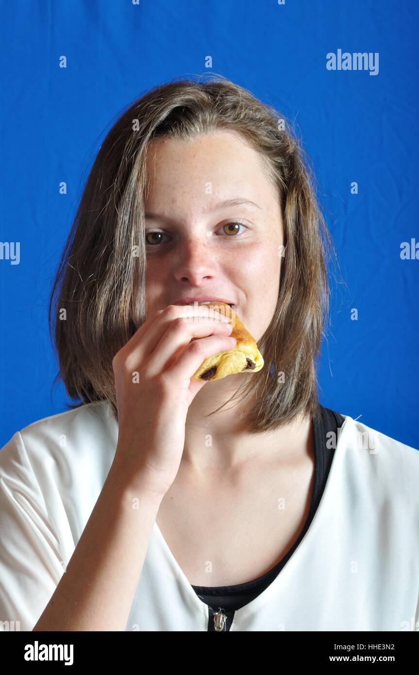 A  teen eating a chocolate bun Stock Photo