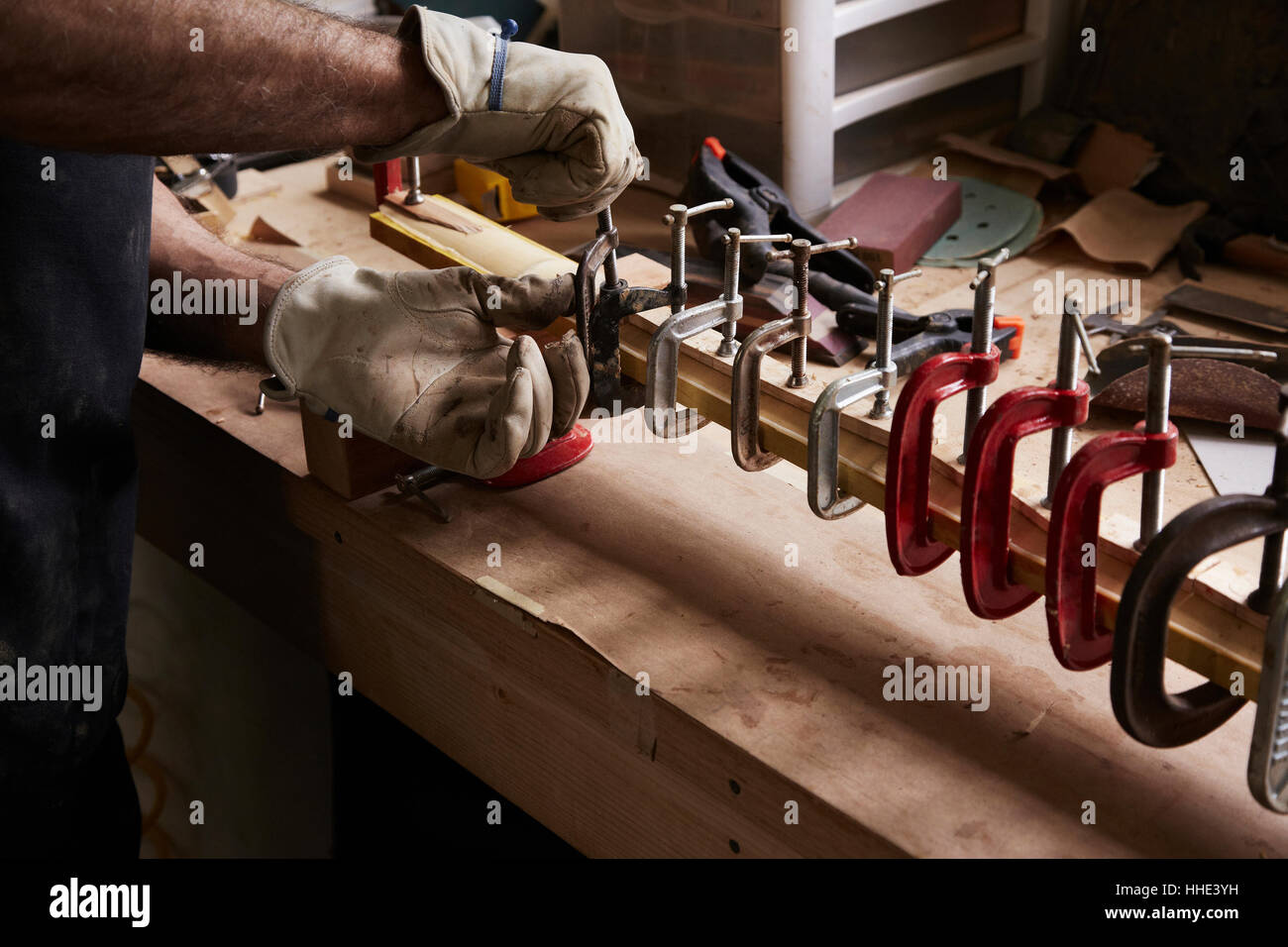 A Bow Maker Working On A Wooden Bow In His Workshop Fixing Clamps On 
