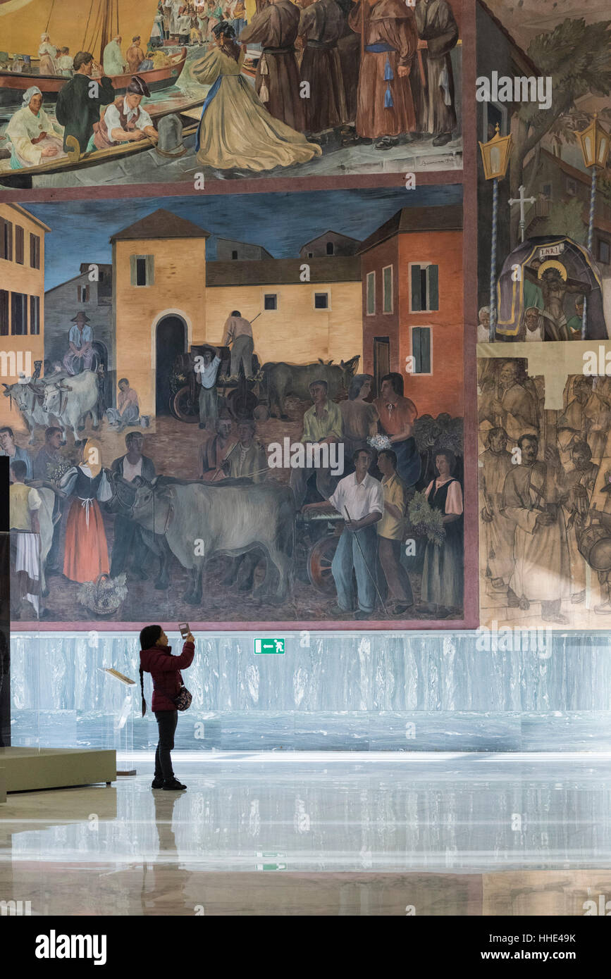 Rome. Italy. Museo Nazionale delle Arti e Tradizioni Popolari, visitor in the Salone d'onore, with frescoes depicting scenes of traditional life Stock Photo