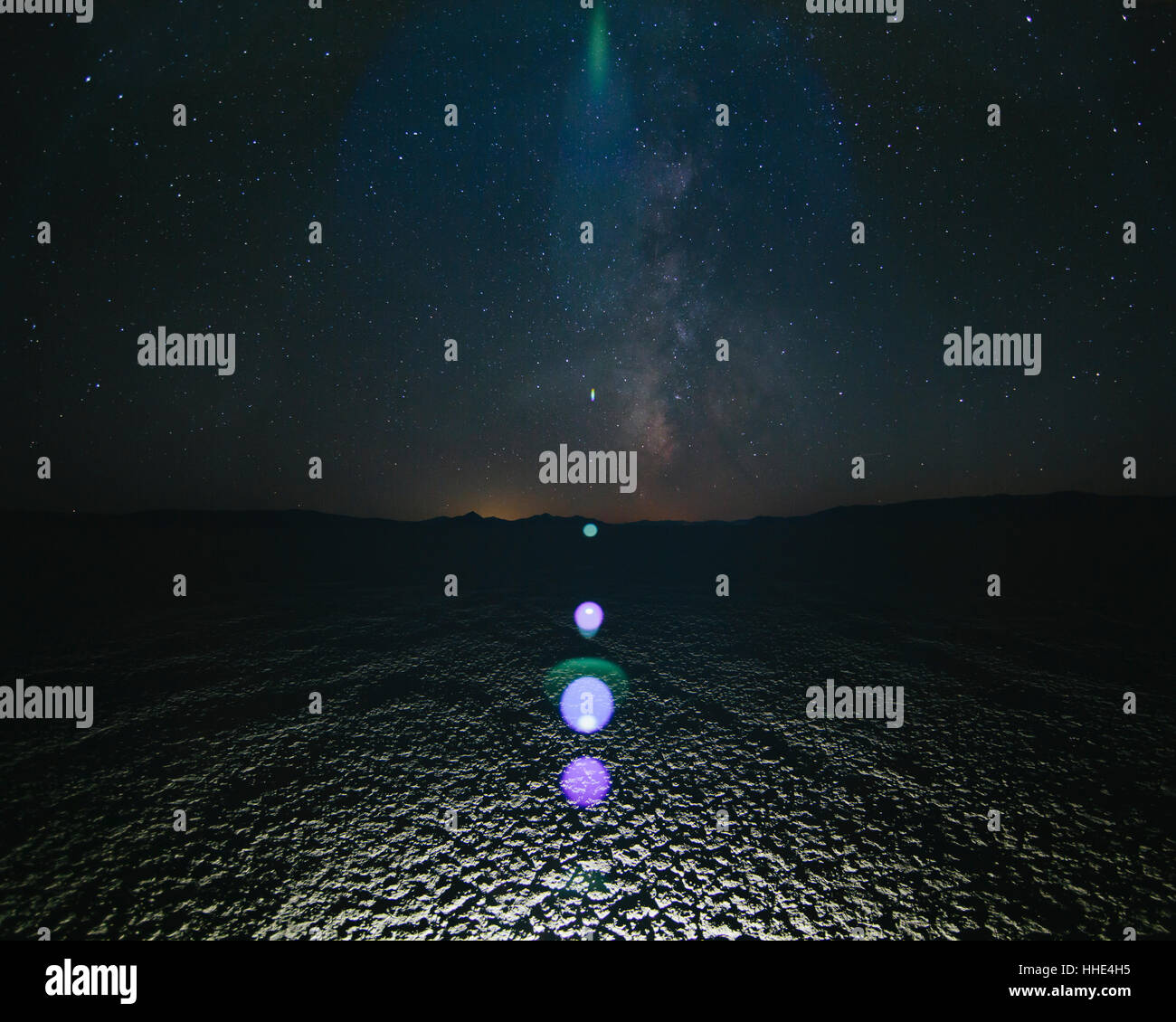 Glowing bright light on playa, night sky and Milky Way above, Black Rock Desert, Nevada Stock Photo