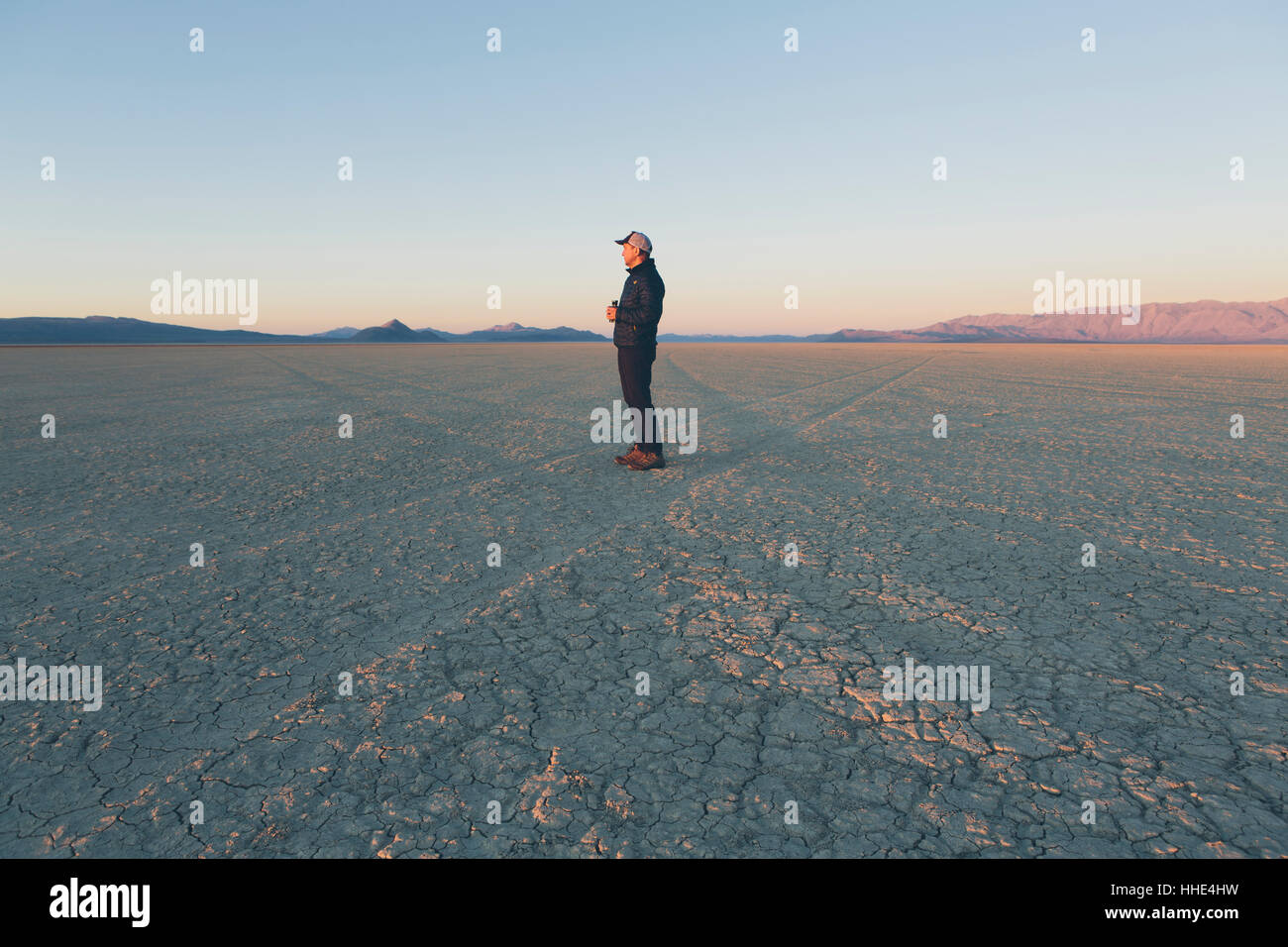 Man standing in vast desert playa at dawn, Black Rock Desert, Nevada Stock Photo