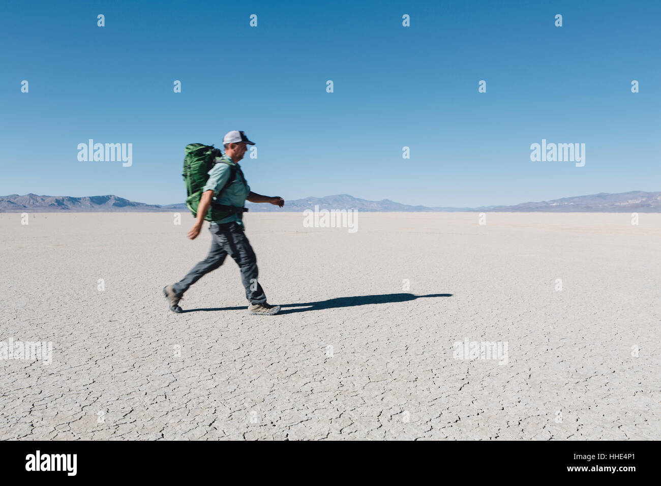 Male backpacker hiking in vast desert, Black Rock Desert, Nevada Stock Photo