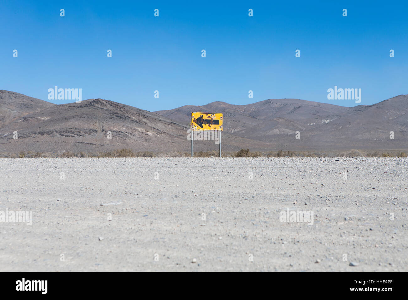 Bullet riddled arrow sign in desert, Black Rock Desert, Nevada Stock Photo