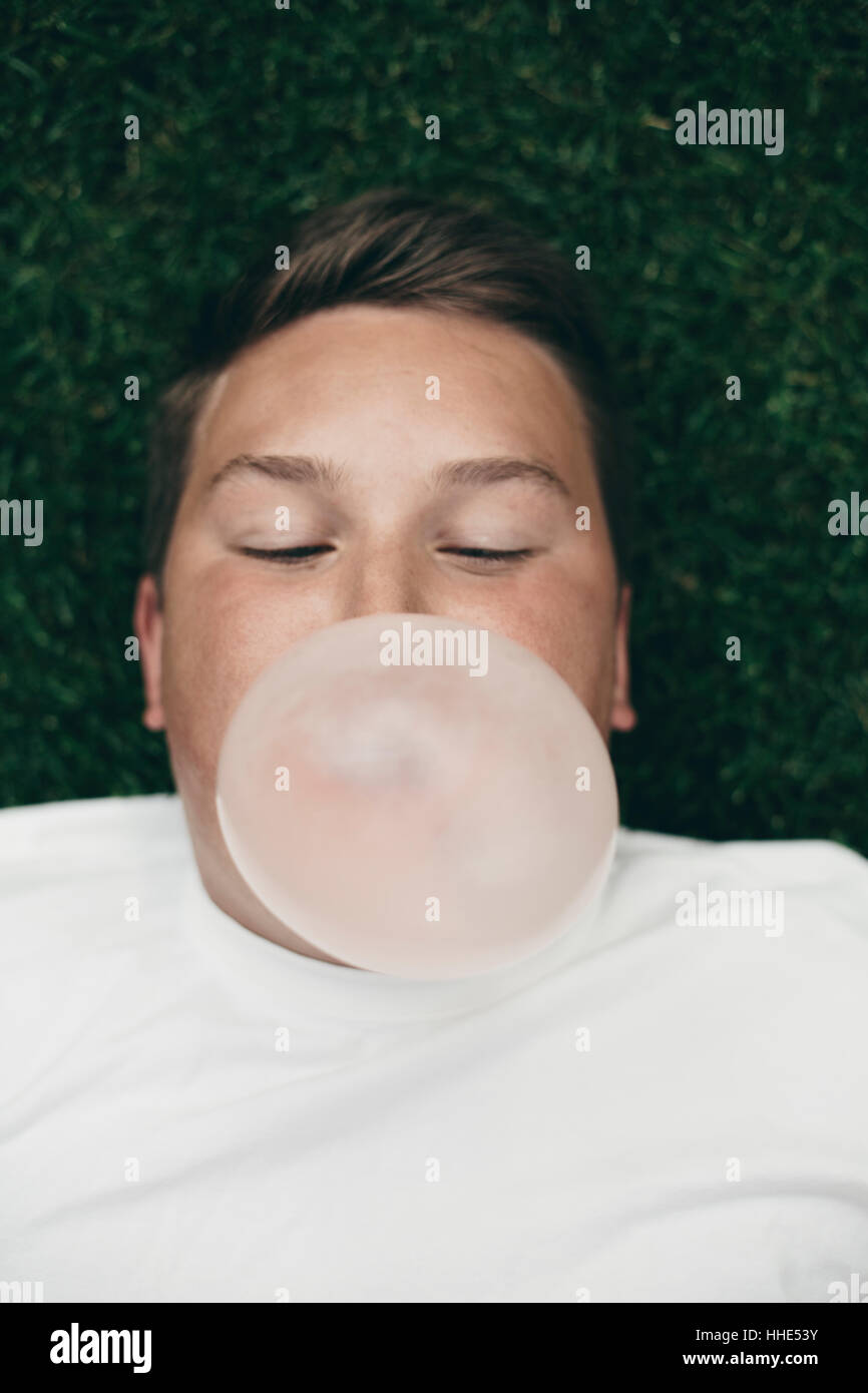 Portrait of teenage boy blowing bubble gum bubble Stock Photo