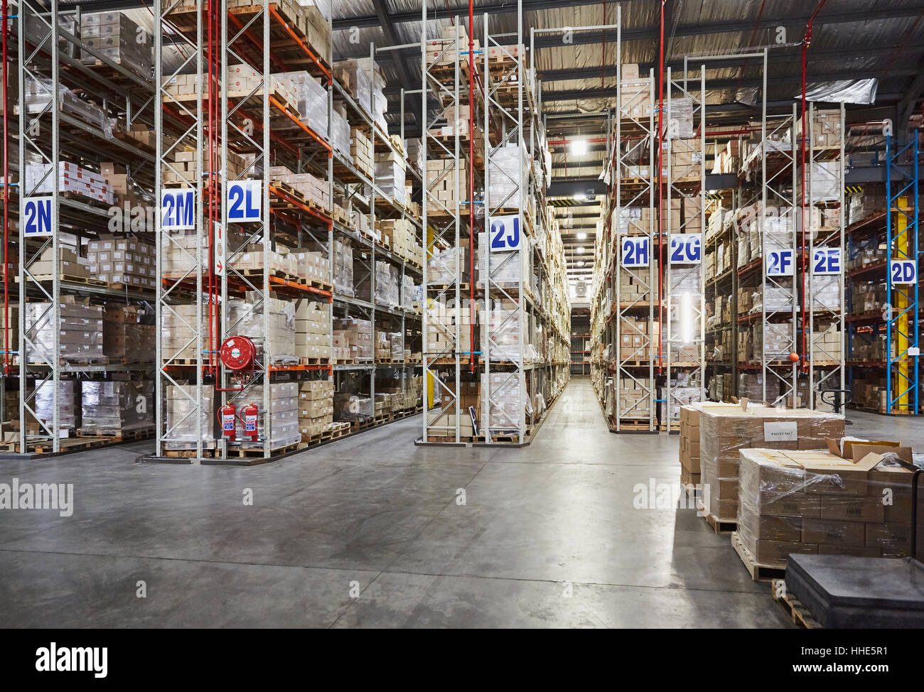 Merchandise stacked on shelves in labeled aisles in distribution