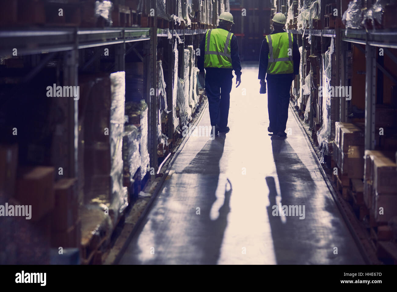 Workers walking in aisle of distribution warehouse Stock Photo
