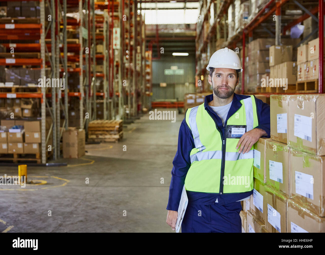 Portrait confident worker leaning on stacked boxes in distribution warehouse Stock Photo